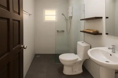 a white bathroom with a toilet and a sink at Payton House Patong - Newly Renovated in Patong Beach