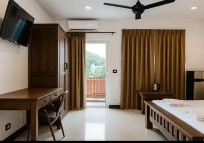 a room with a bed and a desk and a television at Payton House Patong - Newly Renovated in Patong Beach