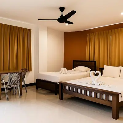 a hotel room with two beds with swans on them at Payton House Patong - Newly Renovated in Patong Beach