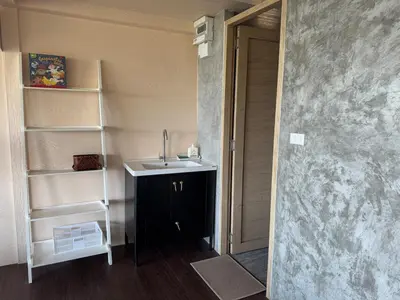 a bathroom with a sink and a book shelf at Choncharm house 2 in Kata Beach