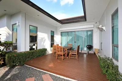 a patio with a table and chairs on a deck at Coconut villa Phuket in Laguna Phuket