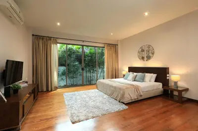 a bedroom with a bed and a large window at Coconut villa Phuket in Laguna Phuket