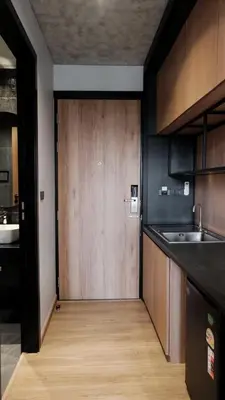a kitchen with a wooden door in the middle at Lush inn Phuket in Ban Suan