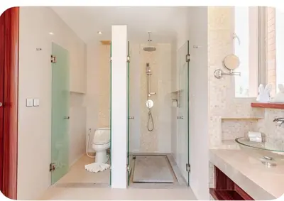 a bathroom with a toilet and a glass shower at Luxuriously private seafront Bangtao beach in Surin Beach