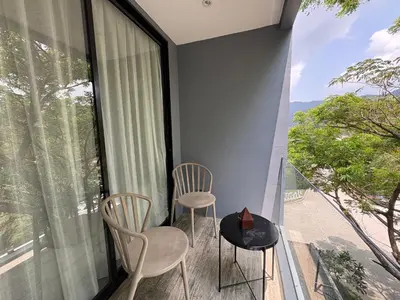 a balcony with two chairs and a table and a window at Citygate Kamala beach, luxury apartment, Phuket in Kamala Beach