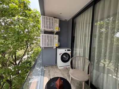 a balcony with a washing machine and a microwave at Citygate Kamala beach, luxury apartment, Phuket in Kamala Beach