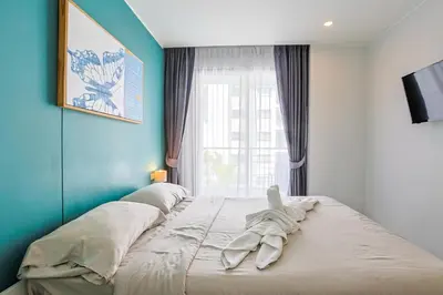 a large bed in a room with a window at Pool View 1 Bed Apt T2-520 in Chalong