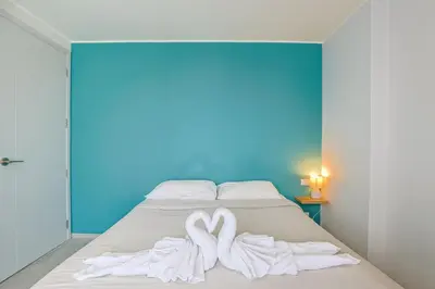 a bed with two white towels in the shape of hearts at Mountain View 1 Bed Apt T2-723 in Chalong