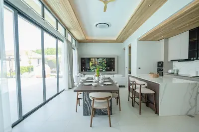 a dining room with a table and chairs at Mouana Breeze Mai Khao 5-bedroom Pool Villa 9914 in Mai Khao Beach