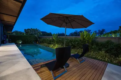 a pool with two chairs and an umbrella at Chalong Bay View 3BR Pool Villa Long One A4 in Chalong
