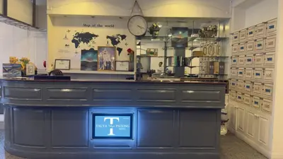 a counter in a store with a clock on the wall at Cocoon Talya Hotel in Patong Beach