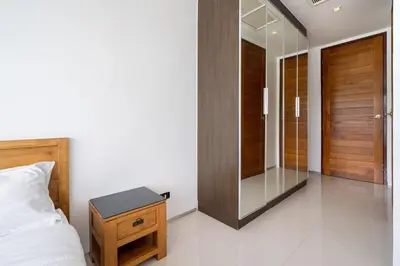 a bedroom with a bed and a mirror and a table at Atika Villas xero oceanfront pool villa in Patong Beach