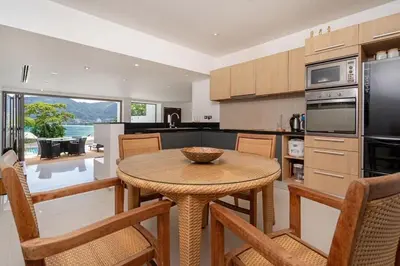 a kitchen with a table and chairs in a kitchen at Atika Villas xero oceanfront pool villa in Patong Beach