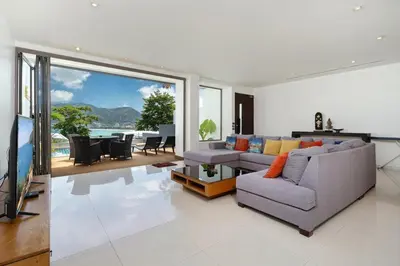 a living room with two couches and a flat screen tv at Atika Villas xero oceanfront pool villa in Patong Beach