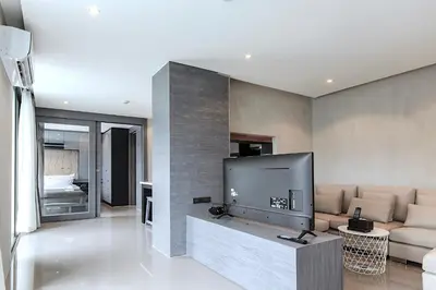a living room with a large flat screen tv at Tropics & Modern Stay - Kamala 2BR Suite CTG L502-3, Best Amenities & Beach Fun in Kamala Beach