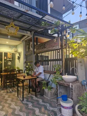 a man sitting at a table in a restaurant at Katika Home 2 in Ban Khlong Haeng