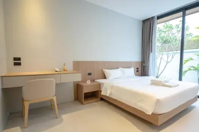 a bedroom with a bed and a desk and a chair at Mouana Breeze Mai Khao 4-bedroom Pool Villa 9918 in Mai Khao Beach