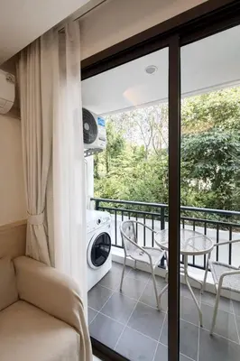 a room with a balcony with a table and a washing machine at 1-bd apartment on Kamala beach in Kamala Beach