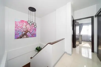 a staircase in a house with a painting on the wall at Duplex Style 3-BR Corner Private Pool Villa in Ban Pak Lak