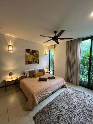 a bedroom with a bed and a ceiling fan at Bangtao Beach Gardens in Surin Beach