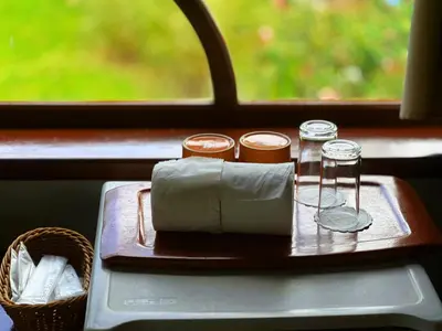 a tray with a napkin and two glasses and a basket at Coco palace resort in Rawai Beach