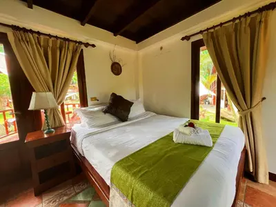 a bedroom with a bed and a window at Coco palace resort in Rawai Beach