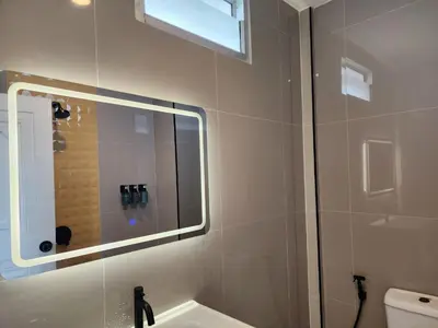 a bathroom with a shower and a sink and a mirror at Wink City 2 Patong Center close to the Beach in Patong Beach