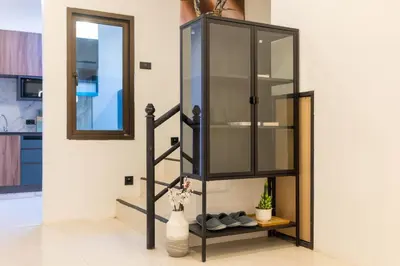 a glass cabinet with shoes on a shelf in a room at Wink Centre House 10 Patong Beach in Patong Beach