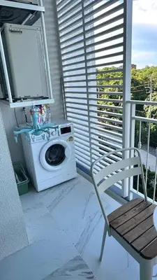 a washing machine and a chair on a balcony at Phuket apartment in Nai Yang Beach