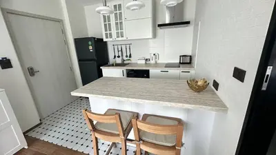 a kitchen with two chairs and a counter top at Phuket apartment in Nai Yang Beach