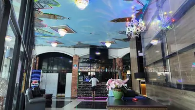 a lobby with a ceiling with umbrellas and flowers at Hangover #1 Hostel Patong in Patong Beach