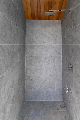 a bathroom with a shower with gray tiles at Chariot by Villacarte in Layan Beach
