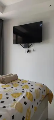 a bedroom with a bed with a tv on the wall at Lovely Mai Khao studio room in Mai Khao Beach