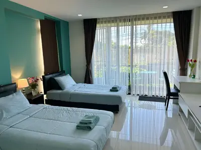 a hotel room with two beds and a window at Serene Panwa beachfront in Ban Ao Makham