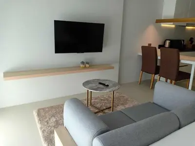 a living room with a couch and a tv at Brand New 2 Bed Seaview Apartment Utopia Karon in Karon Beach