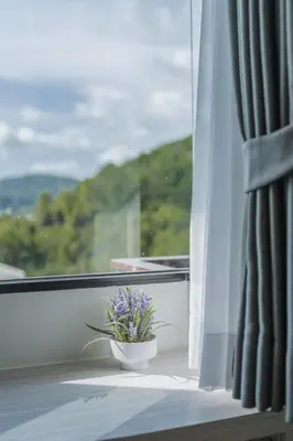 a vase of flowers sitting on a window sill at Brand New 2 Bed Seaview Apartment Utopia Karon in Karon Beach