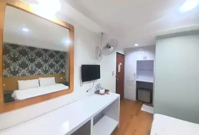 a white room with a bed and a large mirror at Eco Phuket old town in Ban Lo Long