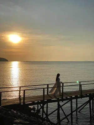 a woman in a wedding dress sitting on a pier at Eco Phuket old town in Ban Lo Long