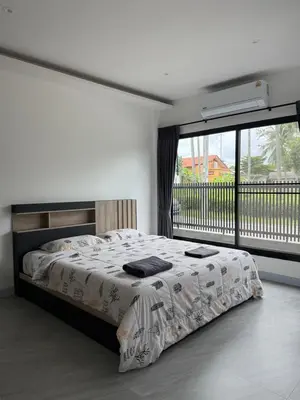 a bedroom with a bed and a large window at P One Apartments in Phuket Town