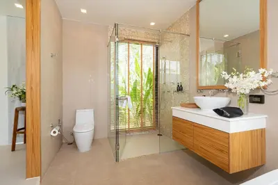 a bathroom with a sink and a shower and a toilet at Anchan Villas Phuket - 4 BR Signature Pool Villa by Escape Villas in Ban Phru Champa