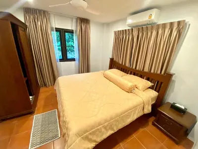 a bedroom with a bed and a window with curtains at Cozy Space Kamala in Kamala Beach