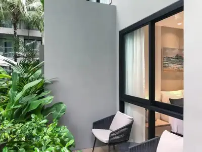 a balcony with a chair and a window at Cozy apartment Banggtao beach in Bang Tao Beach