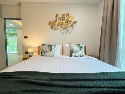 a bedroom with a large bed with pillows at Tropical Living Kamala Hillside in Kamala Beach