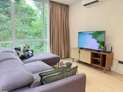 a living room with a couch and a flat screen tv at Tropical Living Kamala Hillside in Kamala Beach