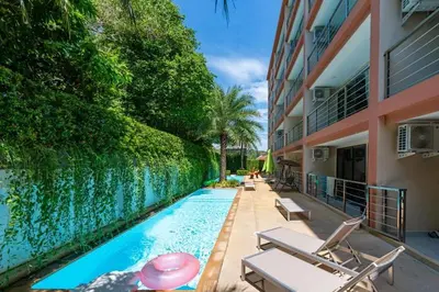 a swimming pool with chairs next to a building at Rawai Apartment RBC 311, near Famous Rawai Market in Phuket Town