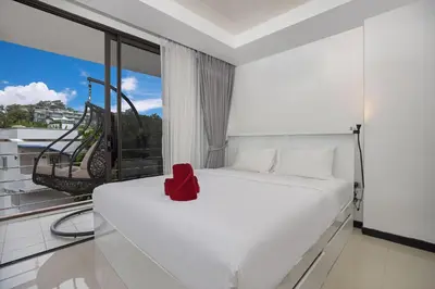 a bedroom with a white bed and a large window at Rawai Apartment RBC 311, near Famous Rawai Market in Phuket Town