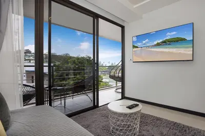 a room with a view of a beach with a tv on the wall at Rawai Apartment RBC 311, near Famous Rawai Market in Phuket Town