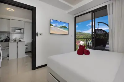 a white room with a view of a kitchen at Rawai Apartment RBC 311, near Famous Rawai Market in Phuket Town