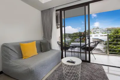 a living room with a couch and a balcony at Rawai Apartment RBC 311, near Famous Rawai Market in Phuket Town