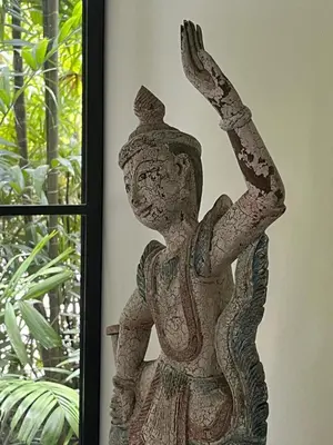a statue of a woman sitting on a chair next to a window at Secret Garden at Bangtao Beach in Surin Beach